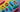 Colorful flat lay of abstract, gender-neutral silicone-like shapes on a soft rainbow pride gradient, symbolizing inclusivity and celebration.