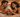 A warm, intimate photograph of an adult couple lying in bed, smiling at each other and sharing a quiet moment of connection in soft ambient light.