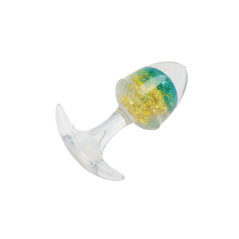Transparent anal plug with clear silicone base and multicolor crystal-like core on plain background.