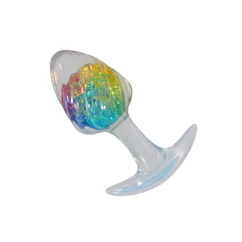 Transparent anal plug with clear silicone base and rainbow crystal-like core on plain background.