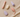 Flat lay photograph showing several pastel-colored wellness products in modern, minimalist shapes, neatly arranged on a neutral beige fabric background with soft daylight and gentle shadows